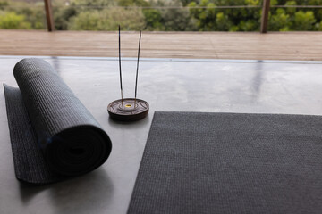 At home, yoga mat and incense burner resting on a sleek surface