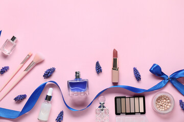 Flat lay composition with different makeup products and beautiful spring flowers on pink...
