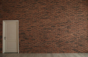 Empty room with brick wall and white door