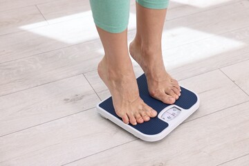 Woman on floor scale at home, closeup. Space for text