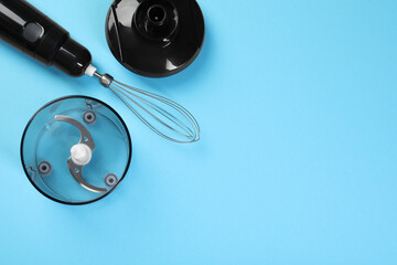 Hand blender kit. Whisk, lid, bowl and bowl chopper on light blue background, flat lay. Space for...