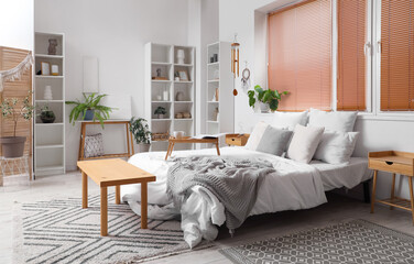 Interior of light bedroom with wind chime, dream catcher and plants