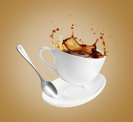 Cup of coffee, saucer and spoon in air on dark beige background