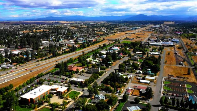 Aerial Scenic View Of Houses In Residential Town By Mountains, Drone Flying Backwards On Sunny Day - Coeur d'Alene, Idaho