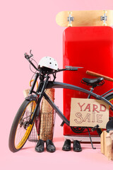 Unwanted stuff for yard sale with bicycle on pink background