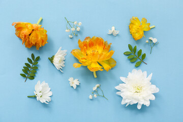 Obraz premium Beautiful composition with different flowers and green leaves on blue background