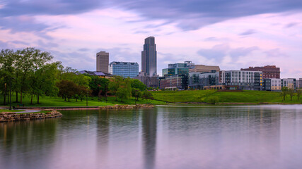 Omaha City Skyline, high-rising buildings, peaceful lake, big sky with floating clouds: The beauty of the midwestern metropolis in Nebraska