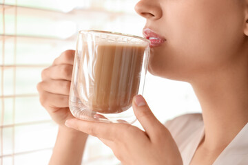 Young woman with drinking hot coffee at home, closeup
