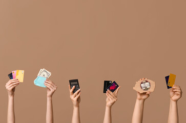 Female hands with credit cards, calculator, wallet and piggy bank on brown background