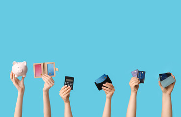 Female hands with credit cards, calculator and piggy bank on blue background
