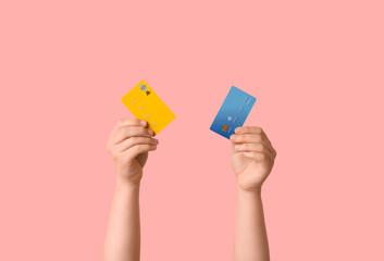 Female hands with credit cards on pink background