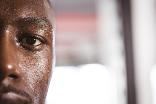 At gym, young African American man sweating after intense workout, copy space