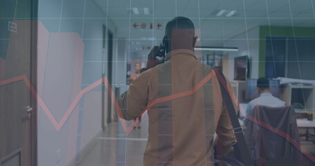 Image of graphs, grid pattern, african american man talking on cellphone while walking in office