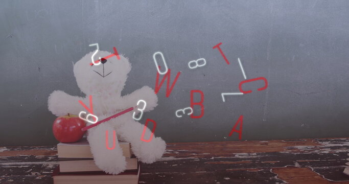 Teddy bear sitting on books, apple resting beside it