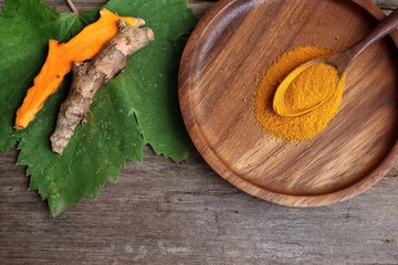 Turmeric root powder on wood background