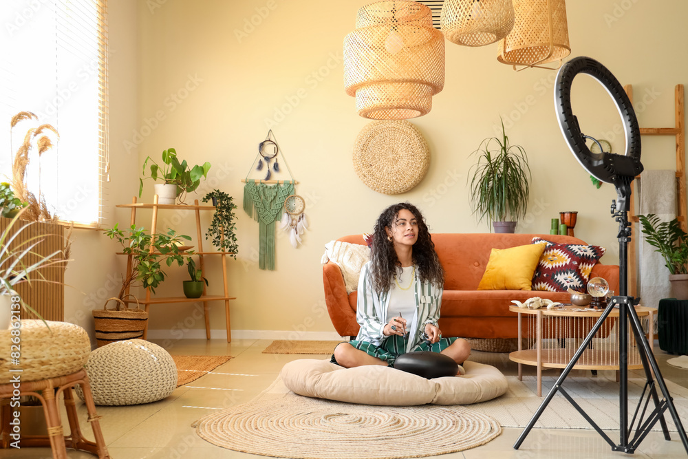 Wall mural young african-american witch with glucophone recording video at home