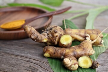 Turmeric root powder on wood background
