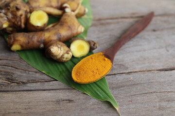 Turmeric root powder on wood background