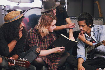 Band, people and notebook for lyrics in music studio with brainstorming, ideas or teamwork for...