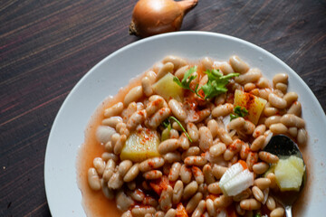White beans with potatoes , carrots , and parsley , on a pot