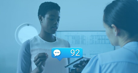 Image of social media icons with numbers over diverse business people having meeting at office