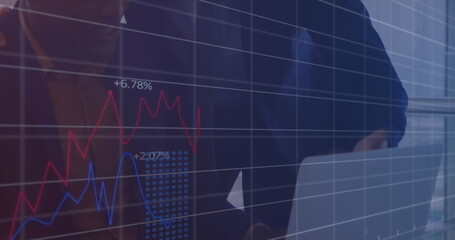 Image of graphs and numbers over diverse male coworkers discussing reports over laptop in office