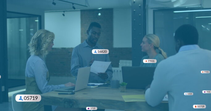 Image of social media icons with numbers over diverse business people having meeting at office - Powered by Adobe