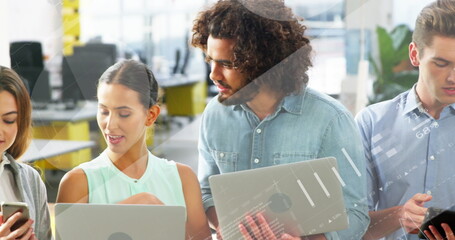 Image of statistical data processing over diverse colleagues using electronic devices at office