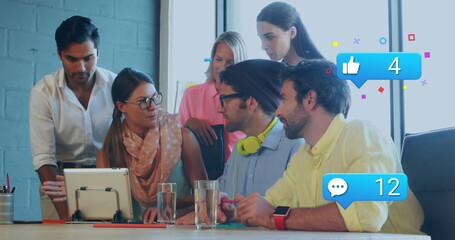 Image of social media icons over diverse colleagues discussing together at office