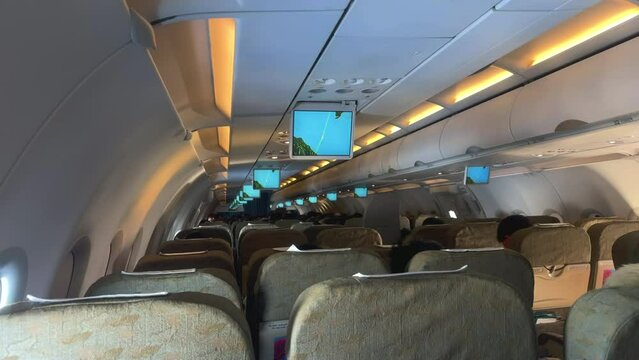 Inside view of passenger plane. Unrecognizable passengers sitting inside an airplane. Commercial airliner. Economy class seating. Airplane row seating in economy class.