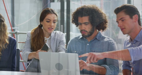 Image of multiple graphs over diverse coworkers discussing reports on laptop in office