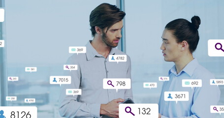 Image of multiple notification bars over diverse coworkers discussing reports on digital tablet