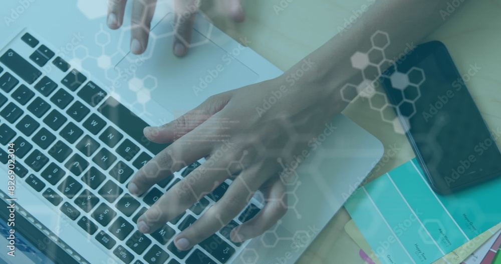 Poster image of computer language and hexagons, overhead view of cropped hands using laptop