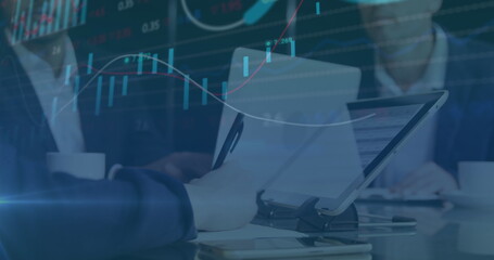 Image of multiple graphs and trading board over caucasian coworkers discussing reports