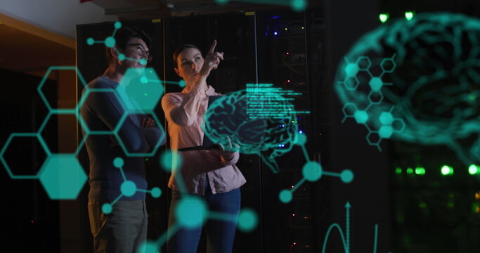 Image of medical data processing over diverse male female engineers discussing at server room - Powered by Adobe