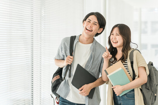 大学・短大・専門学校の校舎・キャンパスを歩く男女カップル・同級生の学生
