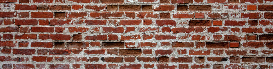 Fragment of old brickwork, wide plan. A wall of red brick. Potholes and defects in a brick wall,...