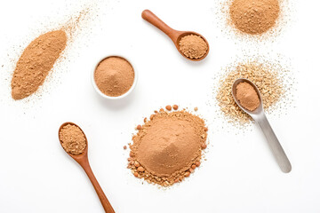 Brown Powder In Spoons And Bowls On White Background
