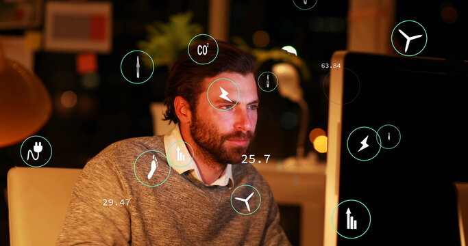 Image of eco icons processing over caucasian businessman using laptop