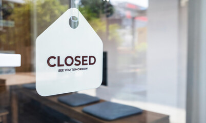 Sign text hangs on the entrance door of the shop, restaurant, cafe. That reads "closed". Business concept