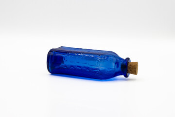 Blue glass bottle with a cork cap on white background