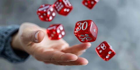 A hand holding red dice with white numbers showing, floating in the air and throwing up bold . The background is a neutral grey to create contrast