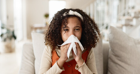 Sick girl, sofa and blowing nose with tissue for virus, infection or congestion in living room at home. Young female person, child or kid with cold, flu or sinus in fatigue, fever or sneeze at house - Powered by Adobe