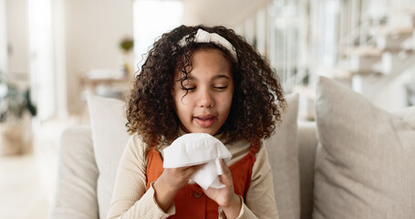 Little girl, sofa and blowing nose with tissue for virus, infection or sneeze in living room at...