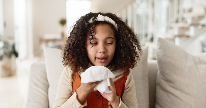 Little girl, sofa and blowing nose with tissue for virus, infection or sneeze in living room at home. Young female person, child or sick kid with congestion, sinus or mucus for cold, flu or fever