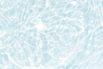 Blue water with ripples on the surface. Defocus blurred transparent blue colored clear calm water surface texture with splashes and bubbles. Water waves with shining pattern texture background.