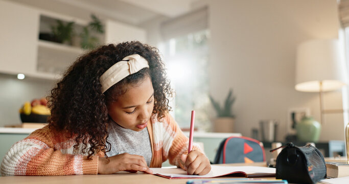 Little Girl, Student And Writing With Book In Kitchen For Homework Or Assessment At Home. Young Female Person, Child Or Kid Taking Notes Or Studying With Stationery For Learning Or Education At House