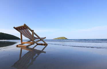 Wooden lounge chairs on a beautiful tropical beach