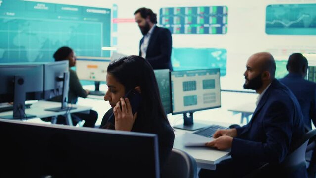 Indian financial consultant answering a phone call from a stakeholder, ensuring progress by communicating key performance indicators. Confident employee shares the current situation. Camera B.
