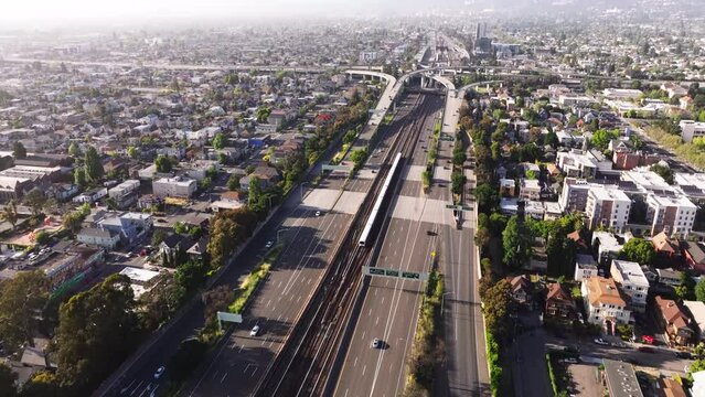 Air over freeway and houses towards skyscrapers in downtown Oakland, California